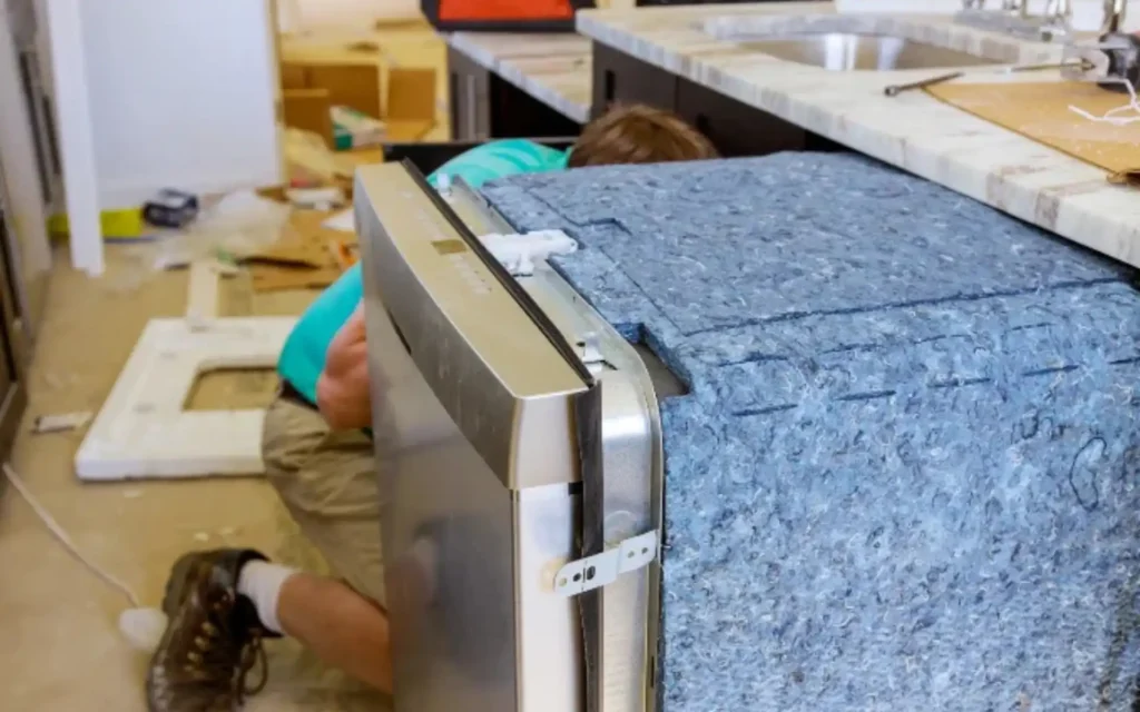 Technician pulling out a washing machine to check the fault